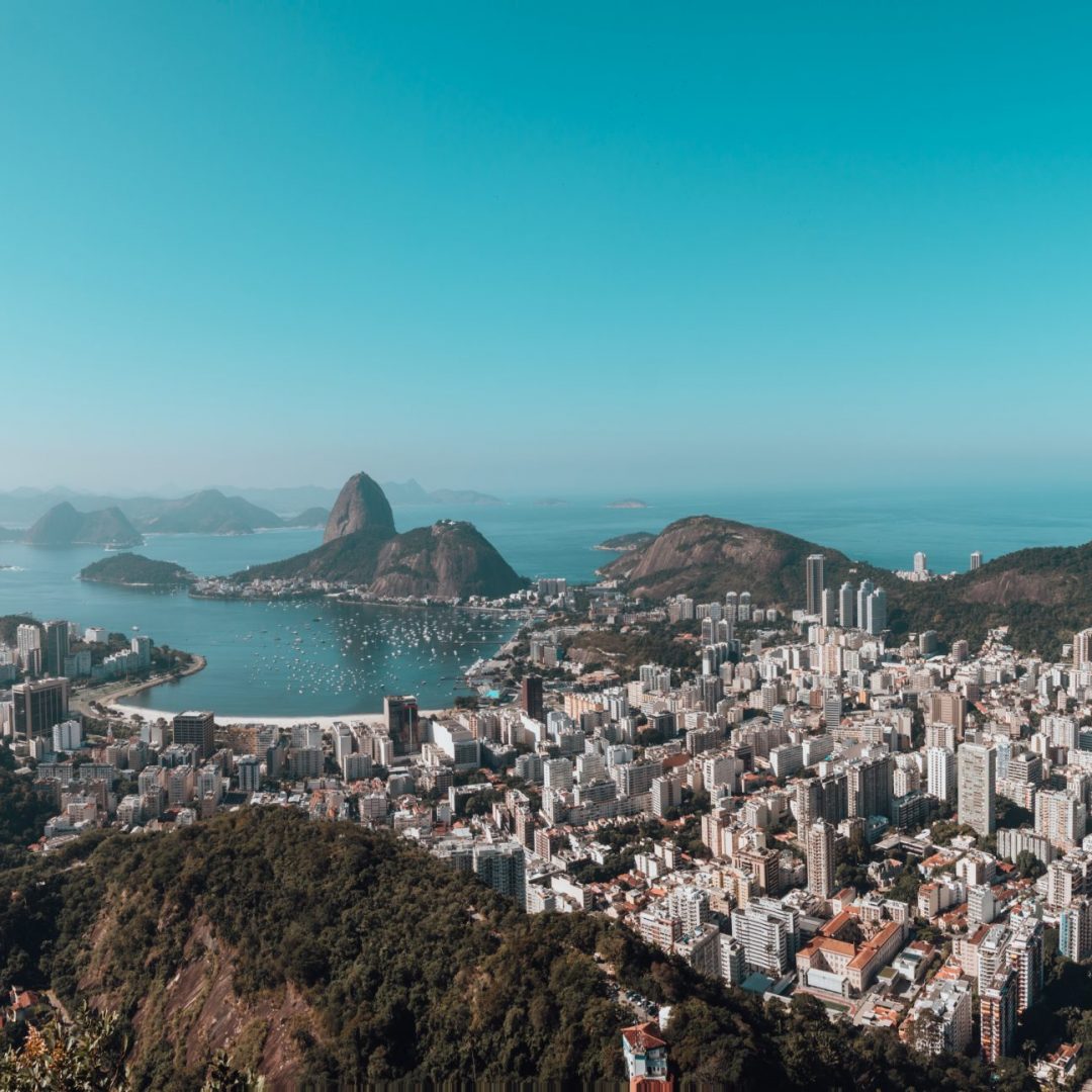 A landscape of Rio De Janeiro surrounded by the sea under a blue sky in Brazil